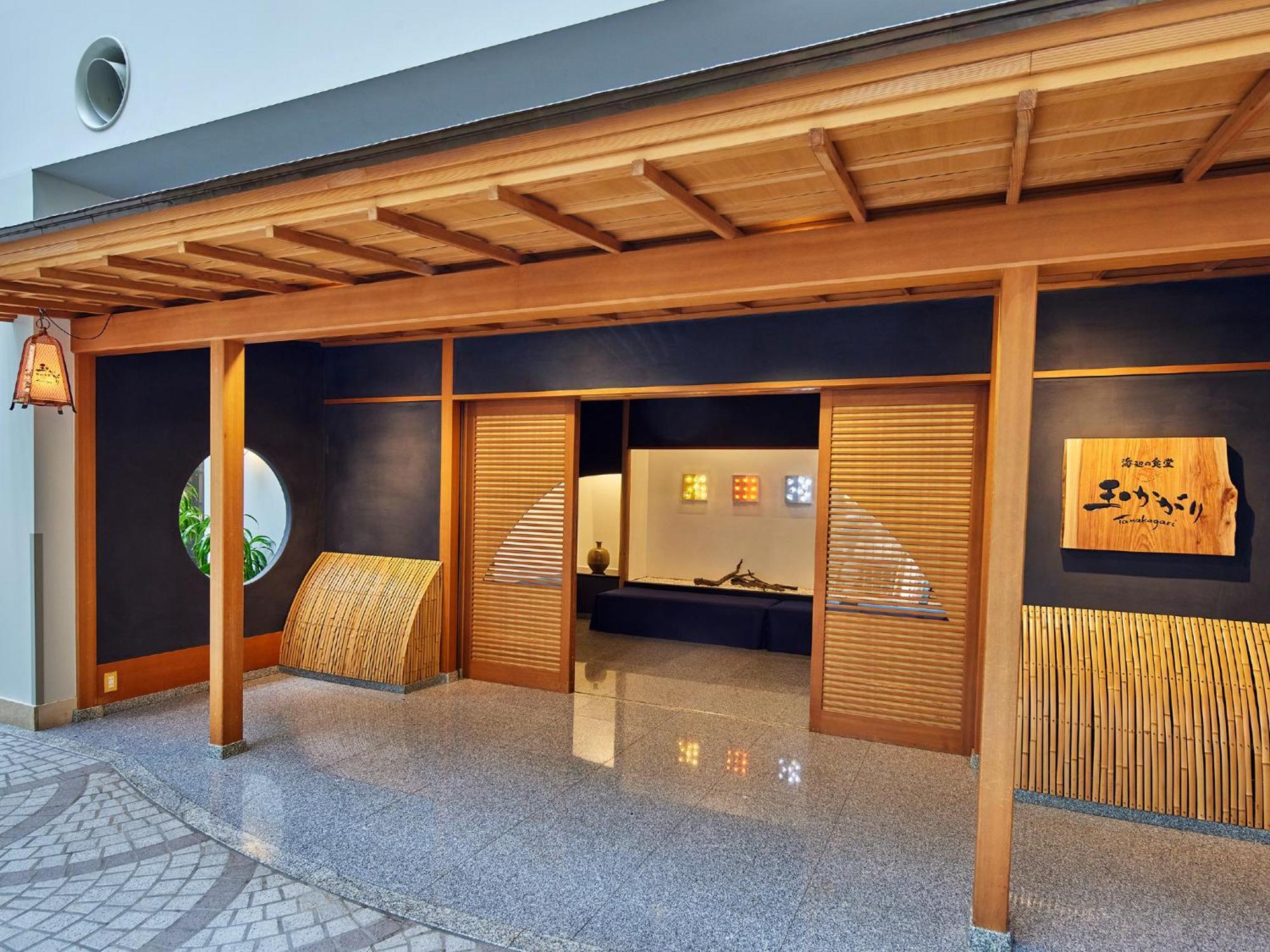 מלון Urayasu Grand Nikko Tokyo Bay Maihama מראה חיצוני תמונה The photo shows the entrance of a building, designed in a traditional Japanese style. It features a wooden structure with a large overhanging roof and sliding doors. The entrance is flanked by rounded windows, and there's a decorative sign with Japan